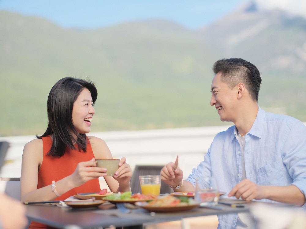 Hãy tưởng tượng cả gia đình vừa đến resort sau một hành trình dài. Thay vì tiếp tục mở điện thoại để tìm nhà hàng, xem hoạt động nào phù hợp với trẻ hay tính xem hôm nay nên chi bao nhiêu, bạn chỉ cần nhìn vào lịch trải nghiệm trong ngày và chọn điều mình muốn làm. Buổi sáng, cha mẹ có thể tập yoga hoặc nghỉ bên hồ bơi. Trẻ em tham gia hoạt động tại Kids Club. Buổi trưa, cả gia đình gặp lại nhau trong nhà hàng. Buổi chiều có thể là bãi biển, thể thao hoặc một khoảng nghỉ yên tĩnh. Đến tối, mọi người cùng ăn uống và xem chương trình tại resort. Đó là ý tưởng nền tảng của Premium All-Inclusive: một kỳ nghỉ nơi phần lớn nhu cầu chính đã được chuẩn bị trong cùng một hệ sinh thái. Premium All-Inclusive là gì? Premium All-Inclusive là mô hình nghỉ dưỡng trọn gói cao cấp, trong đó các nhu cầu chính như phòng nghỉ, ăn uống, đồ uống, hoạt động, thể thao, giải trí và một số dịch vụ trẻ em được tích hợp trong cùng một gói. Điểm đáng chú ý không chỉ là số lượng dịch vụ được bao gồm. Giá trị lớn hơn nằm ở sự thuận tiện. Khách có thể dự toán phần lớn chi phí chính, giảm bớt thời gian lên kế hoạch và hạn chế những quyết định phát sinh mỗi ngày. Với gia đình có trẻ nhỏ, mô hình này giúp cha mẹ không phải tự tìm hoạt động cho con từ sáng đến tối. Với cặp đôi hoặc nhóm bạn, Premium All-Inclusive tạo ra nhiều lựa chọn nghỉ dưỡng, vận động và giải trí mà không cần đặt riêng từng phần. All-inclusive có nghĩa là gì? “All-inclusive” có thể hiểu là nghỉ dưỡng trọn gói. Thay vì chỉ đặt phòng rồi thanh toán riêng cho bữa ăn, đồ uống, hoạt động hoặc dịch vụ trẻ em, khách mua một gói lớn hơn, trong đó nhiều quyền lợi đã được tính sẵn. Tuy nhiên, mỗi gói all-inclusive có phạm vi khác nhau. Không nên hiểu rằng mọi nhà hàng, mọi đồ uống, mọi hoạt động hoặc mọi dịch vụ tại resort đều miễn phí. Câu hỏi quan trọng trước khi đặt không phải chỉ là “có all-inclusive không”, mà là “gói này bao gồm chính xác những gì”. (Ảnh 2: Phòng nghỉ, bữa ăn, đồ uống, hoạt động và Kids Club có thể cùng nằm trong một hệ sinh thái nghỉ dưỡng.) Premium All-Inclusive khác gì all-inclusive thông thường? Không có một tiêu chuẩn toàn cầu duy nhất cho khái niệm Premium All-Inclusive. Thông thường, chữ “Premium” thể hiện việc thương hiệu chú trọng hơn đến chất lượng lưu trú, ẩm thực, đồ uống, hoạt động, dịch vụ gia đình và cách toàn bộ kỳ nghỉ được tổ chức. All-inclusive thông thường tập trung vào sự tiện lợi và kiểm soát chi phí. Premium All-Inclusive hướng đến trải nghiệm cao hơn: nhiều hoạt động hơn, dịch vụ được tổ chức tốt hơn và cảm giác nghỉ dưỡng liền mạch hơn. Tiêu chí All-inclusive thông thường Premium All-Inclusive Mục tiêu chính Thuận tiện, dễ kiểm soát chi phí Thuận tiện kết hợp trải nghiệm chất lượng cao Phòng nghỉ Đáp ứng nhu cầu lưu trú cơ bản Chú trọng thiết kế, tiện nghi và vị trí Ăn uống Các bữa ăn theo khung giờ Nhiều lựa chọn ẩm thực và trải nghiệm đa dạng hơn Đồ uống Danh mục cơ bản Danh mục rộng hơn, nhưng một số loại cao cấp vẫn có thể tính phí Hoạt động Một số hoạt động giải trí Nhiều môn thể thao, lớp học hoặc thiết bị hơn Trẻ em Khu vui chơi hoặc dịch vụ cơ bản Chương trình theo độ tuổi tại nhiều resort Giải trí Chương trình chung Hoạt động ban ngày và biểu diễn buổi tối Phù hợp với Khách ưu tiên sự đơn giản Khách muốn cân bằng nghỉ dưỡng và trải nghiệm Dù vậy, Premium không đồng nghĩa với mọi thứ đều riêng tư hoặc cá nhân hóa tuyệt đối. Một số resort Premium All-Inclusive có không khí sôi động, nhiều hoạt động cộng đồng và phù hợp với gia đình. Nếu khách cần villa biệt lập, quản gia riêng hoặc không gian cực kỳ yên tĩnh, vẫn cần kiểm tra hạng phòng và loại resort phù hợp. Premium All-Inclusive thường bao gồm những gì? Một kỳ nghỉ Premium All-Inclusive thường bao gồm phòng nghỉ theo hạng đã chọn, các bữa ăn, đồ ăn nhẹ, nhiều loại đồ uống, hoạt động thể thao, chương trình giải trí và Kids Club cho một số độ tuổi. Phòng nghỉ phụ thuộc vào hạng phòng, sức chứa, vị trí và số khách. Các bữa ăn có thể gồm buffet, nhà hàng theo quy định hoặc một số trải nghiệm ẩm thực. Open bar thường có danh mục đồ uống rộng, nhưng rượu cao cấp, champagne hoặc đồ uống đặc biệt có thể tính thêm. Hoạt động thể thao là một điểm đáng chú ý. Tùy resort, khách có thể thử yoga, tennis, pickleball, bắn cung, kayak, snorkeling, sailing hoặc các lớp nhóm theo lịch. Kids Club cũng là quyền lợi quan trọng với gia đình, nhưng độ tuổi, chi phí và điều kiện tham gia cần được kiểm tra kỹ. Những dịch vụ nào có thể tính thêm? Một số khoản thường có thể phát sinh gồm vé máy bay, transfer, visa, bảo hiểm, spa, massage, excursion ngoài resort, scuba diving, dịch vụ trẻ nhỏ dưới một số độ tuổi, đồ uống cao cấp, rượu nguyên chai, dịch vụ tại phòng, nâng hạng phòng, giặt ủi, mua sắm và chi tiêu cá nhân. Vì vậy, “trọn gói” nên được hiểu là phần lớn nhu cầu chính đã được tích hợp, không phải mọi thứ trong resort đều không giới hạn. Một báo giá rõ ràng cần tách ba phần: đã bao gồm, chưa bao gồm và dịch vụ tùy chọn. (Ảnh 3: Hiểu rõ phần đã bao gồm và phần có thể tính thêm giúp gia đình tránh nhầm lẫn khi đặt kỳ nghỉ.) Vì sao Premium All-Inclusive phù hợp với nhiều gia đình? Gia đình là nhóm nhận được nhiều giá trị từ mô hình này vì nhu cầu trong một chuyến đi thường rất đa dạng. Trẻ em cần hoạt động theo độ tuổi. Cha mẹ cần thời gian riêng. Ông bà cần nhịp độ nhẹ nhàng. Một số thành viên muốn vận động, người khác chỉ muốn nghỉ. Nếu phải tự tổ chức tất cả, chuyến đi dễ trở thành công việc thứ hai của người phụ trách. Premium All-Inclusive giúp giảm áp lực đó. Gia đình có sẵn nhiều lựa chọn trong cùng một nơi, ít phải di chuyển, dễ kiểm soát chi phí chính và có nhiều cơ hội để mỗi người tận hưởng theo cách riêng. Khi nào không nên chọn Premium All-Inclusive? Mô hình này có thể chưa phù hợp nếu bạn chỉ cần nơi ngủ qua đêm, muốn dành hầu hết thời gian ngoài resort, thích ăn ở nhà hàng địa phương mỗi ngày hoặc không sử dụng hoạt động đi kèm. Nếu ngân sách ưu tiên giá phòng thấp nhất, hoặc bạn thích tự lên kế hoạch từng chi tiết, khách sạn truyền thống hay hành trình tự túc có thể hợp lý hơn. Một kỳ nghỉ Premium All-Inclusive đáng tiền nhất khi gia đình thật sự sử dụng những quyền lợi đã trả trước. Checklist nhanh trước khi đặt Trước khi chọn một resort Premium All-Inclusive, hãy tự hỏi: • Gia đình có trẻ em không? • Có cần Kids Club không? • Mọi người có muốn dùng phần lớn bữa ăn trong resort không? • Có muốn tham gia hoạt động tại chỗ không? • Có muốn giảm thời gian tự lên lịch không? • Có cần dễ dự toán chi phí không? • Có dự định dành phần lớn thời gian trong resort không? Nếu phần lớn câu trả lời là có, Premium All-Inclusive có thể là lựa chọn phù hợp. (Ảnh 4: Khi những quyết định nhỏ đã được giảm bớt, người tổ chức chuyến đi cũng có thể thật sự tận hưởng kỳ nghỉ.) Trọn gói không phải để làm nhiều hơn, mà để lo ít hơn Một kỳ nghỉ trọn gói tốt không được đánh giá bằng việc bạn dùng hết bao nhiêu dịch vụ. Giá trị thật nằm ở việc gia đình có bớt mệt không, người tổ chức có được nghỉ không, trẻ em có trải nghiệm riêng không và cả nhà có thêm thời gian chất lượng không. Premium All-Inclusive không dành cho tất cả mọi người. Nhưng với những gia đình muốn một kỳ nghỉ dễ tổ chức, nhiều lựa chọn và ít áp lực hơn, đây là mô hình rất đáng cân nhắc.