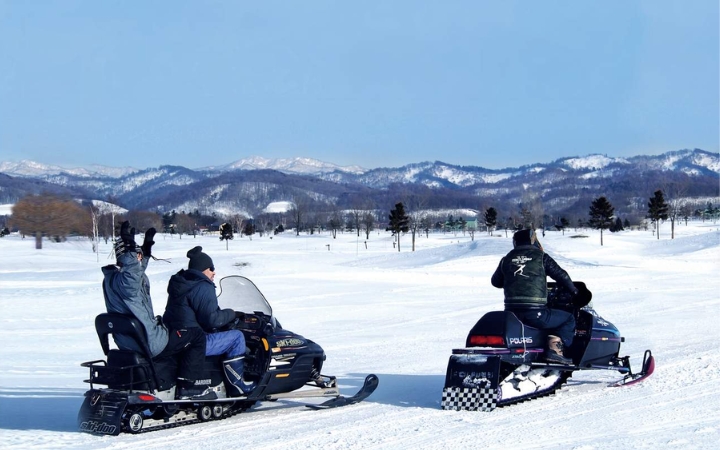 Du khách trải nghiệm lái xe trượt tuyết tại Bibai Snow Land giữa khung cảnh mùa đông tuyệt đẹp