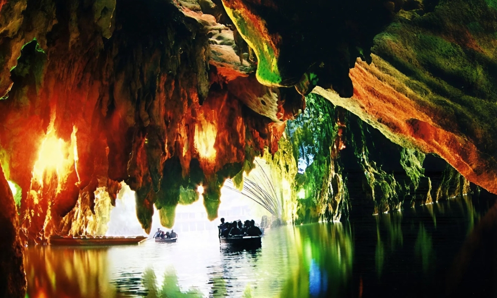 Khung cảnh kỳ ảo bên trong hang động Long Cung với thạch nhũ lấp lánh và dòng sông ngầm uốn lượn giữa lòng núi