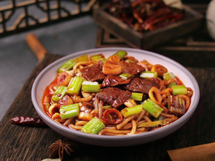 Đĩa mỳ gạo chiên nóng hổi với màu sắc hấp dẫn, điểm xuyết những lát hành và thịt cừu Tân Cương.