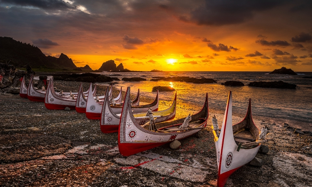 Những chiếc thuyền truyền thống của người Đạt Ngõa xếp hàng bên bờ biển Lan Tự trong ánh hoàng hôn rực rỡ